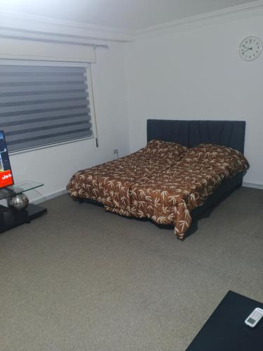 a bedroom with a bed with a brown comforter at Kamaliyeh studio in Amman
