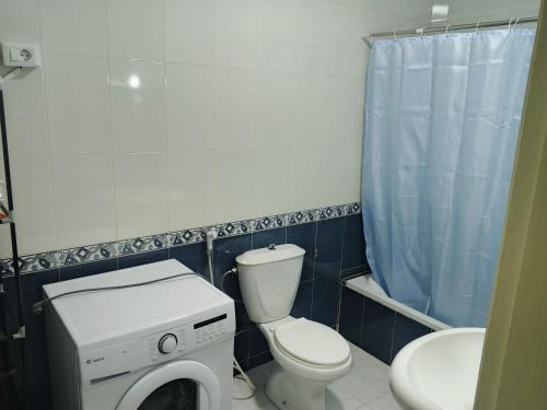 a bathroom with a toilet and a washing machine at Kamaliyeh studio in Amman