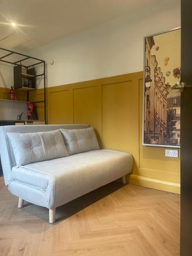 a couch in a room with a yellow wall at Dublin City Centre Holiday Let in Dublin
