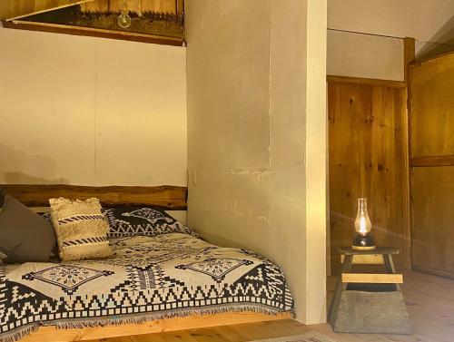 a bedroom with a bed and a table with a lamp at La Cachette - Vacation STAY 34953v in Ina
