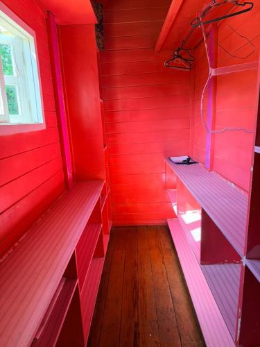 a red room with red walls and wooden floors at Woods Hostel in Belo Horizonte