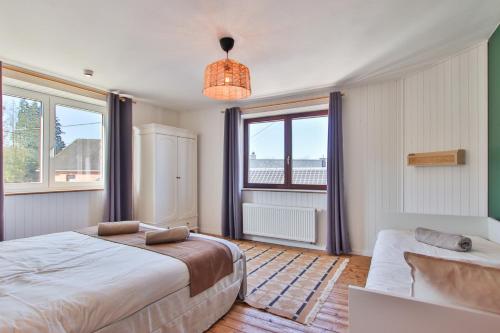 a bedroom with a bed and a large window at Le gîte l'écureuil in Malmedy