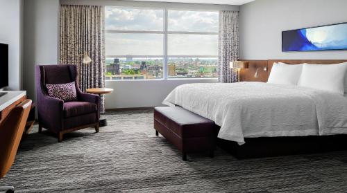 a hotel room with a bed and a chair and a window at Hilton Garden Inn Chicago McCormick Place in Chicago