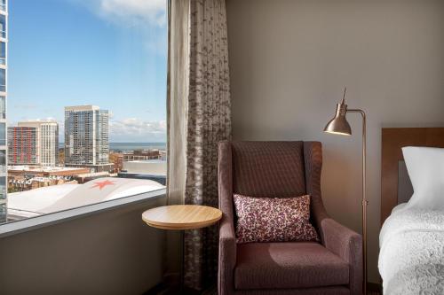 a room with a chair and a window with a view at Hilton Garden Inn Chicago McCormick Place in Chicago