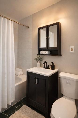 a bathroom with a sink and a toilet and a mirror at Jefferson - 20 mins to Manhattan, NYC in West New York