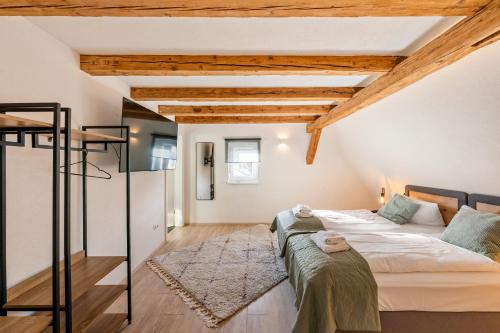 a bedroom with a bed in a room with wooden ceilings at Sali Homes- Penthouse in Obersulm