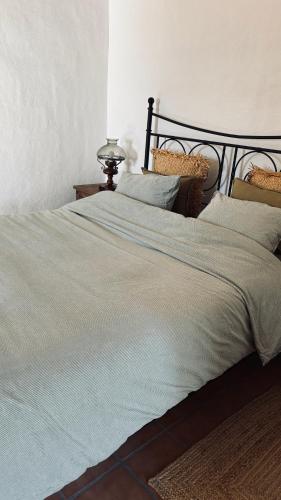 a bedroom with a large bed with blue sheets and pillows at MOZa LUZe - Off Grid Casa Rural in El Pilar y Provincias