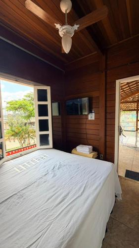a bedroom with a large bed with a ceiling fan at Woods Hostel in Belo Horizonte