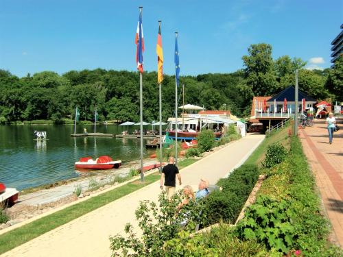 a group of people walking along a path next to a river at Hotel Holsteinische Schweiz am Dieksee in Malente