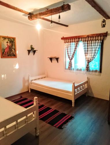 a bedroom with two beds and a window at Kuća iz zavičaja in Kuršumlija