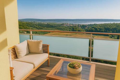 a balcony with a couch and a table with a view at OleaVista in Portorož