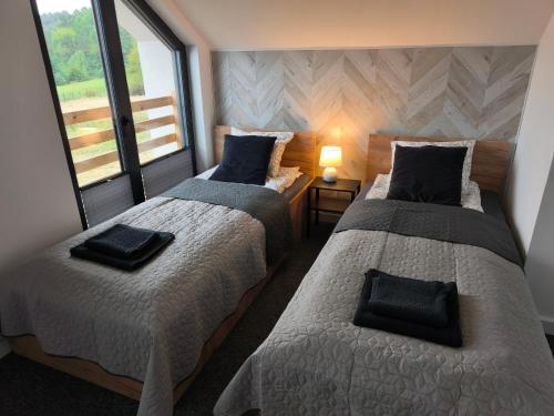 two beds in a small room with windows at Dom z widokiem na góry in Zawodzie