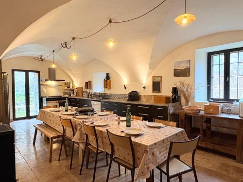 a large kitchen with a long table and chairs at La grange du dévoluy in Le Dévoluy