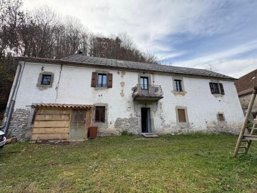 an old white house with a door and a balcony at La grange du dévoluy in Le Dévoluy