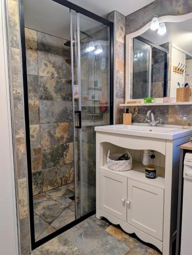 a bathroom with a sink and a shower at Le Chant des Arbres in Grane