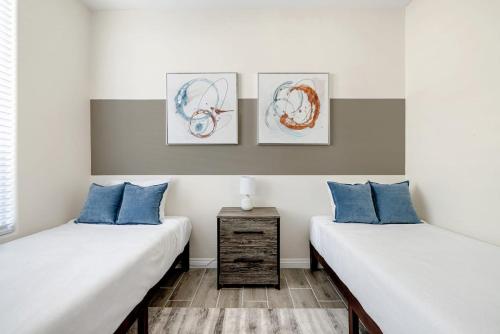 two beds in a room with blue pillows at Sandcastle House Pool, Spa, Golf! in Queen Creek