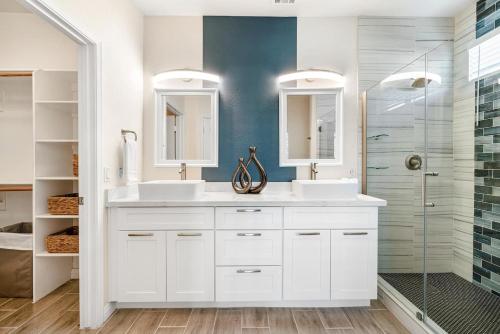 a white bathroom with two sinks and a shower at Sandcastle House Pool, Spa, Golf! in Queen Creek