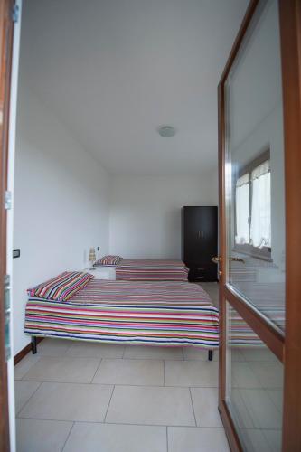a bedroom with a bed and a window and a door at villetta a schiera in Intra