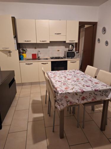 a kitchen with a table with a flowered table cloth at villetta a schiera in Intra