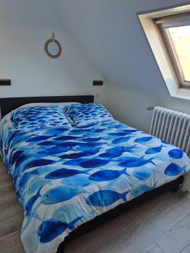 a bed with a blue comforter in a bedroom at maison prairie in Haguenau