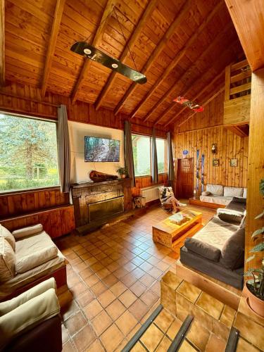 a large living room with wooden walls and ceilings at Nevada Hostel in San Carlos de Bariloche