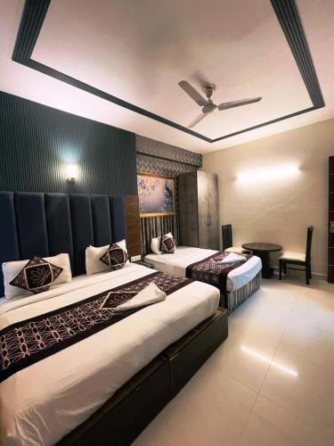 a bedroom with two beds and a ceiling fan at Hotel HSP Suites - Near IGI Airport, New Delhi in New Delhi