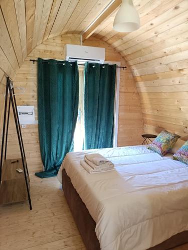 a bedroom with a large bed with green curtains at Quinta do Carvalho - Nature Guest Houses in Guimarães