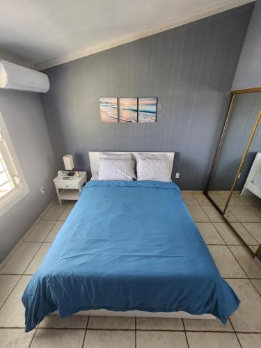 a bedroom with a blue bed with a blue blanket at Costa Azul Apartment in Punta Santiago