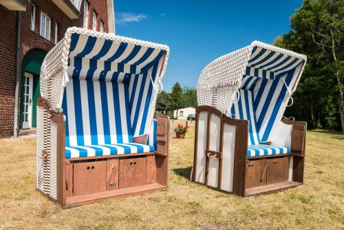 two chairs sitting on the grass in front of a building at Ferienhotel Alter Bahnhof garni in Prerow