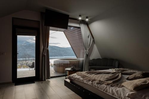 a bedroom with a bed and a large window at Azimuth in Buhalniţa