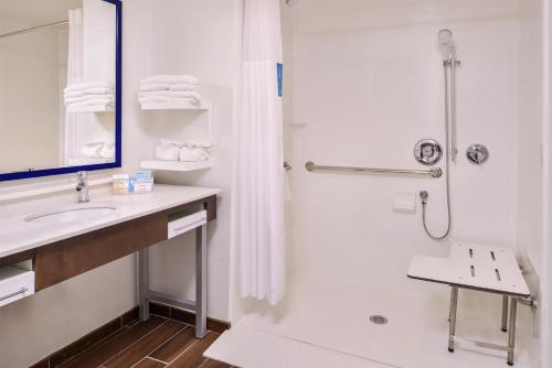 a white bathroom with a shower and a sink at Hampton Inn Benson in Benson