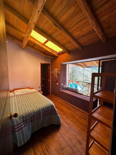 a bedroom with a bed and a large window at Wallpari Sonqo temazcal hostel Comunidad in Pisac