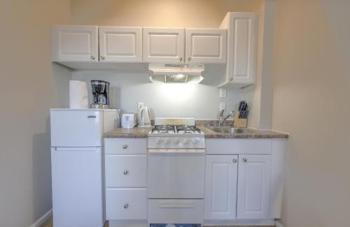 a white kitchen with a stove and a refrigerator at Urban Chic South End Studio in Boston