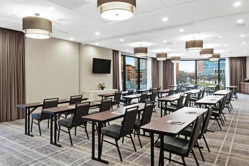 a dining room with tables and chairs and windows at Homewood Suites by Hilton Providence Downtown in Providence