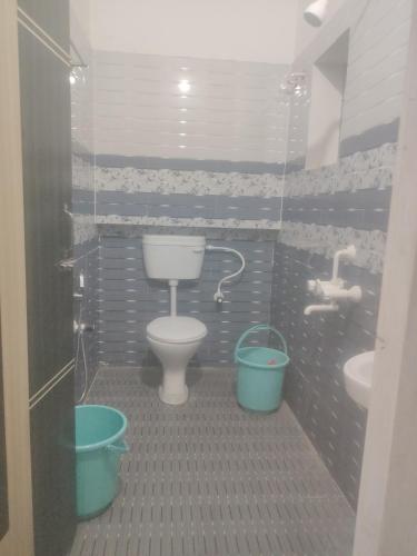 a bathroom with a toilet and a sink at Morisika lodge in Guwahati