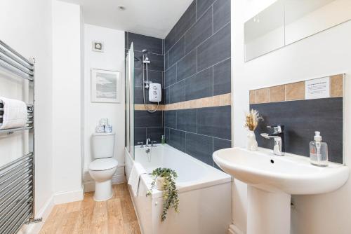 a bathroom with a white sink and a toilet at Large 5Bed Town House-Sleeps 9-By FabAccommodation in Bristol