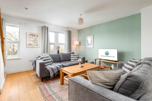 a living room with two couches and a table at Large 5Bed Town House-Sleeps 9-By FabAccommodation in Bristol