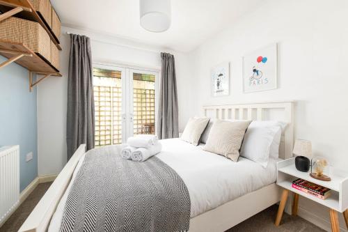 a bedroom with a white bed and a window at Large 5Bed Town House-Sleeps 9-By FabAccommodation in Bristol