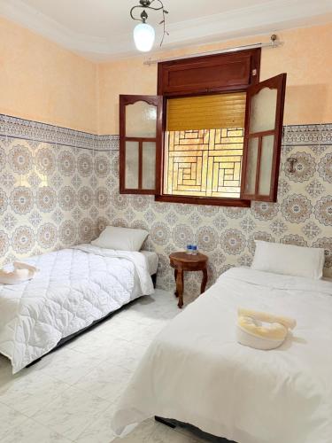 a bedroom with two beds and a window at Airport agadir villa in Agadir