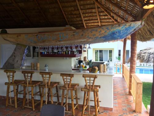 a bar with a boat hanging from a roof at Las Galeras Hotel in Las Galeras