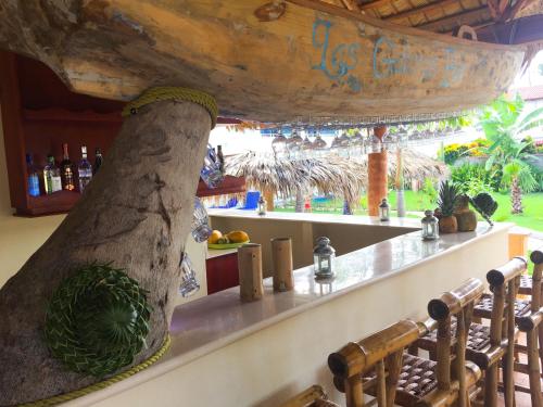 a bar at a resort with a large tree trunk at Las Galeras Hotel in Las Galeras