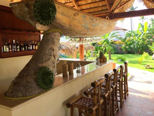 a bar with chairs at a bar with a large boat at Las Galeras Hotel in Las Galeras