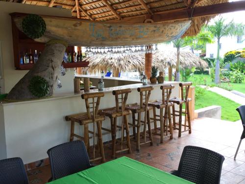 a bar in a restaurant with chairs and a table at Las Galeras Hotel in Las Galeras