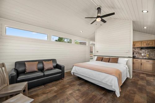 a bedroom with a bed and a black leather couch at Zion Vacation Cabins in Virgin