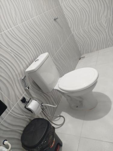 a bathroom with a toilet and a trash can at Pousada Casa do Arthur in Barreirinhas