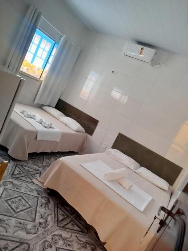 a room with two beds and a window at Pousada Casa do Arthur in Barreirinhas