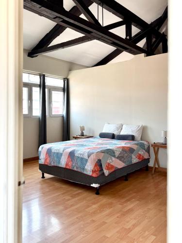 a bedroom with a bed in a room with wooden floors at Casa Elizabeth Apartamentos in Quetzaltenango