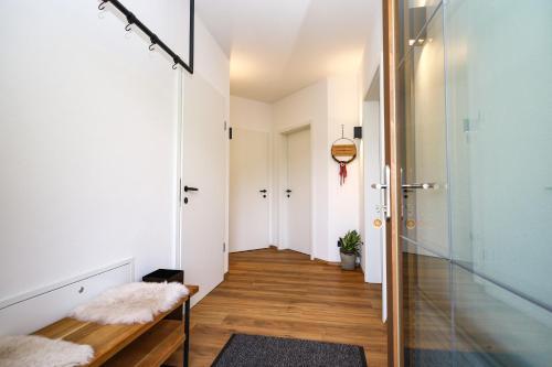 a hallway with white walls and wooden flooring and a bench at Apartment Alpbachtraum in Alpbach