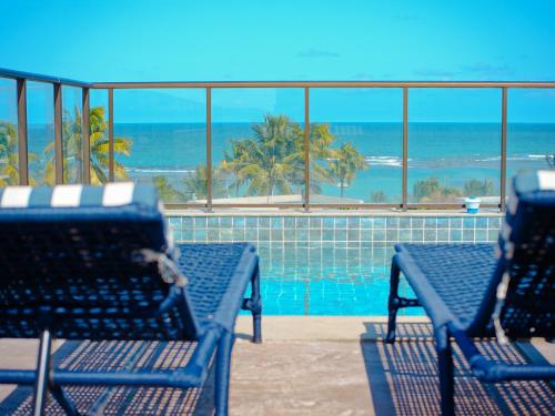 two blue benches sitting next to a swimming pool at Porto de Galinhas PORTO EXCLUSIVE BY AFT in Porto De Galinhas