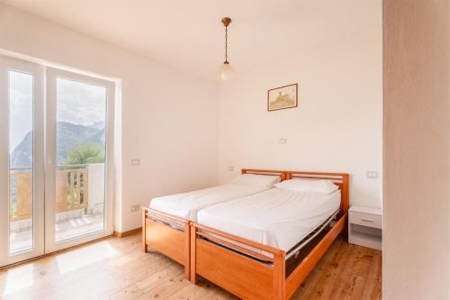 a bedroom with a bed and a large window at Villa Dream alla Beppa in Tenno